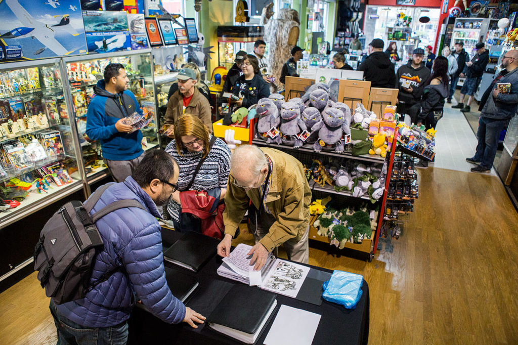 Roger Sweet, who helped design Mattel’s Masters of the Universe characters, signs memorabilia Saturday at BobaKhan Toys & Collectibles in Everett. (Olivia Vanni / The Herald)
