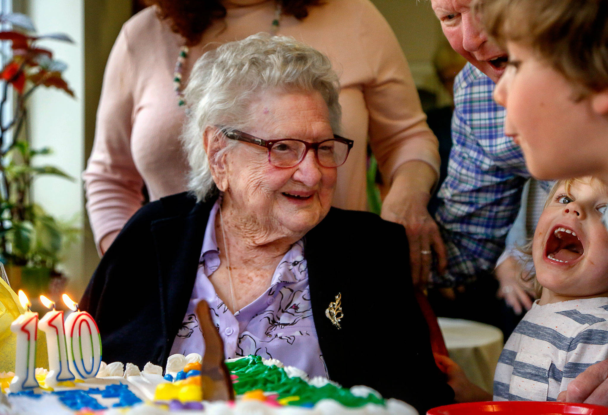 Dozens of relatives and friends gathered Monday to wish LaVerne Bunney a happy 110th birthday at Brookdale Arbor Place in Everett. Her grandson, Doug Ware, watches Gideon Oravetz, 7, and Oden Roehl, 3, help blow out candles. (Dan Bates / The Herald)