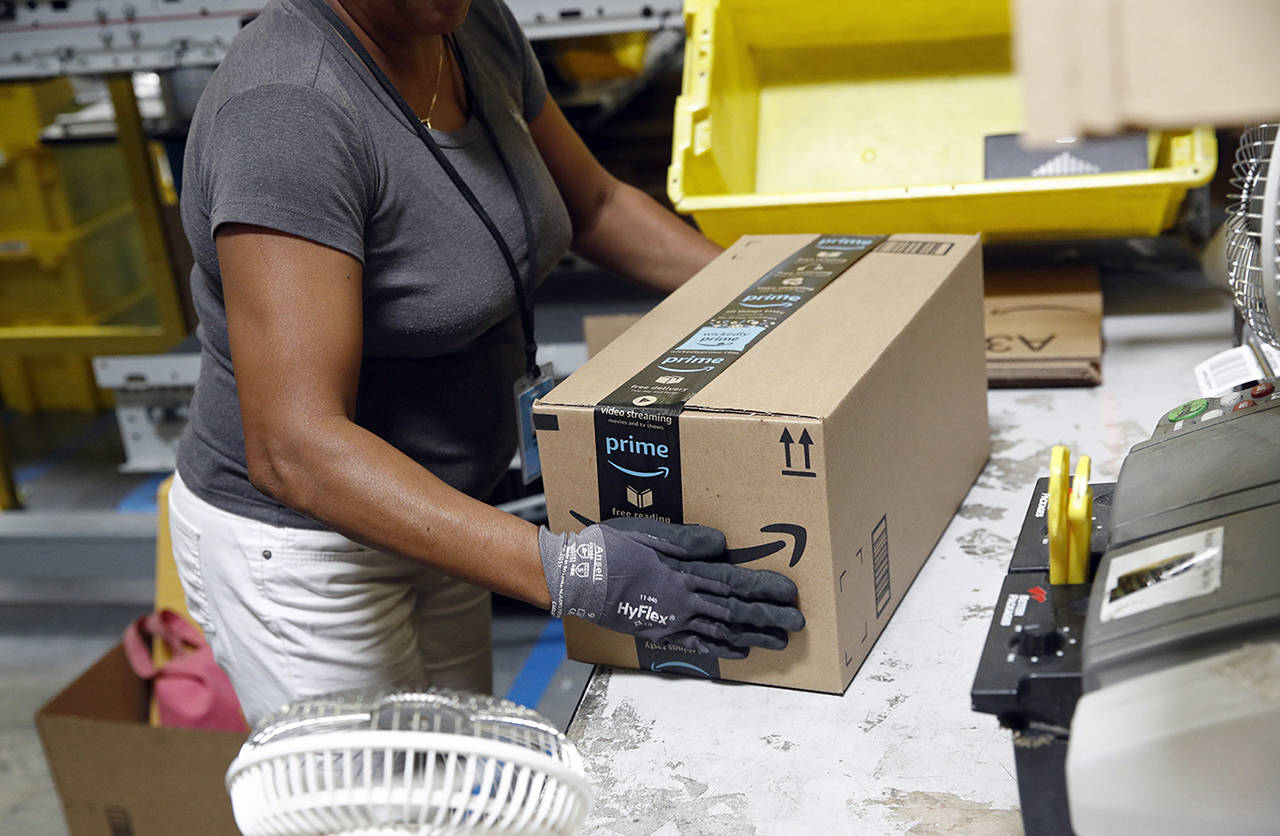 In this 2017 photo, an Amazon employee applies tape to a package before shipment at an Amazon fulfillment center in Baltimore. (AP Photo/Patrick Semansky, File)