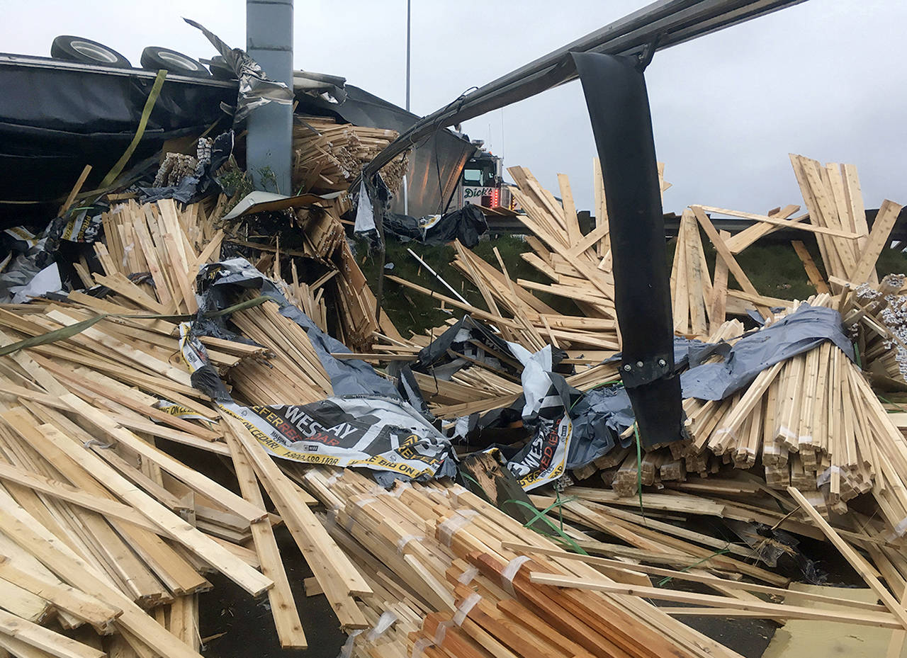 A truck lost a load of lumber after overturning on southbound I-5 near Pacific St. in Everett on Friday morning. (Sue Misao / The Herald)