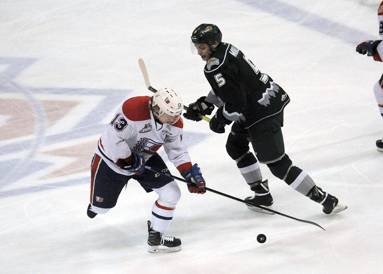 The Silvertips’ Artyom Minulin (right) and the Chiefs’ Riley Woods battle for the puck during the first period of a playoff game on April 13, 2019, in Spokane. (Kathy Plonka / The Spokesman-Review)