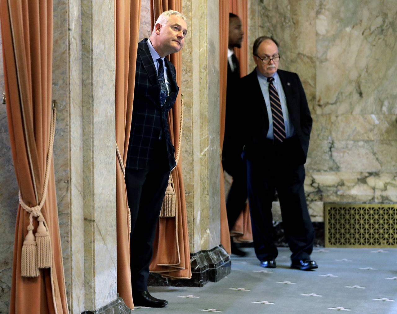 Sen. Reuven Carlyle, D-Seattle (center), watches from the wings of the House floor Thursday at the Capitol in Olympia. Carlyle is the sponsor of Senate Bill 5376. (AP Photo/Ted S. Warren, file)