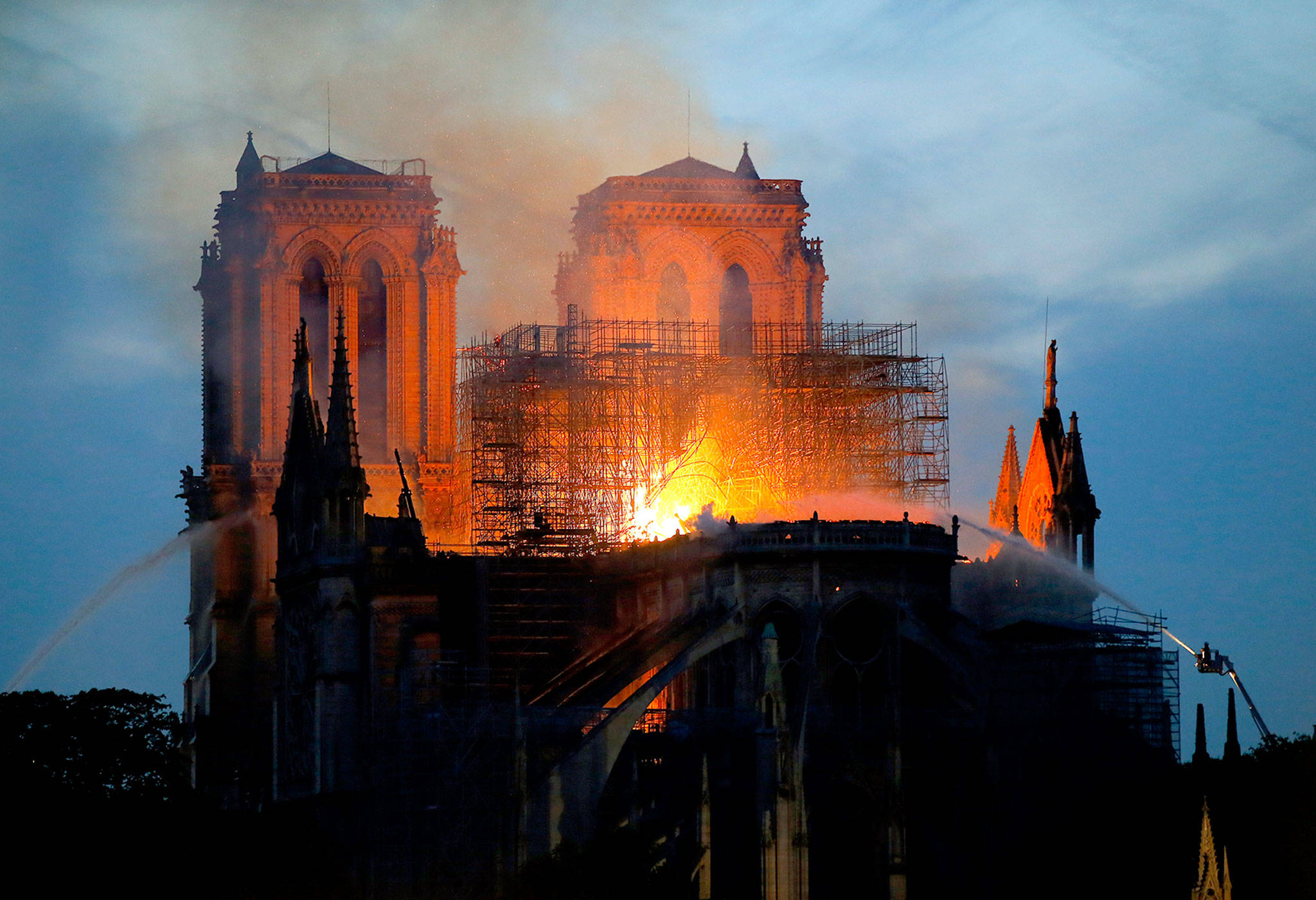 Firefighters pour water on flames as Notre Dame cathedral burns in Paris on Monday. (AP Photo/Michel Euler)