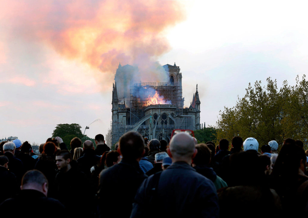 Thibault Camus / Associated Press
People watch as flames and smoke rise from Notre Dame cathedral as it burns Monday.
