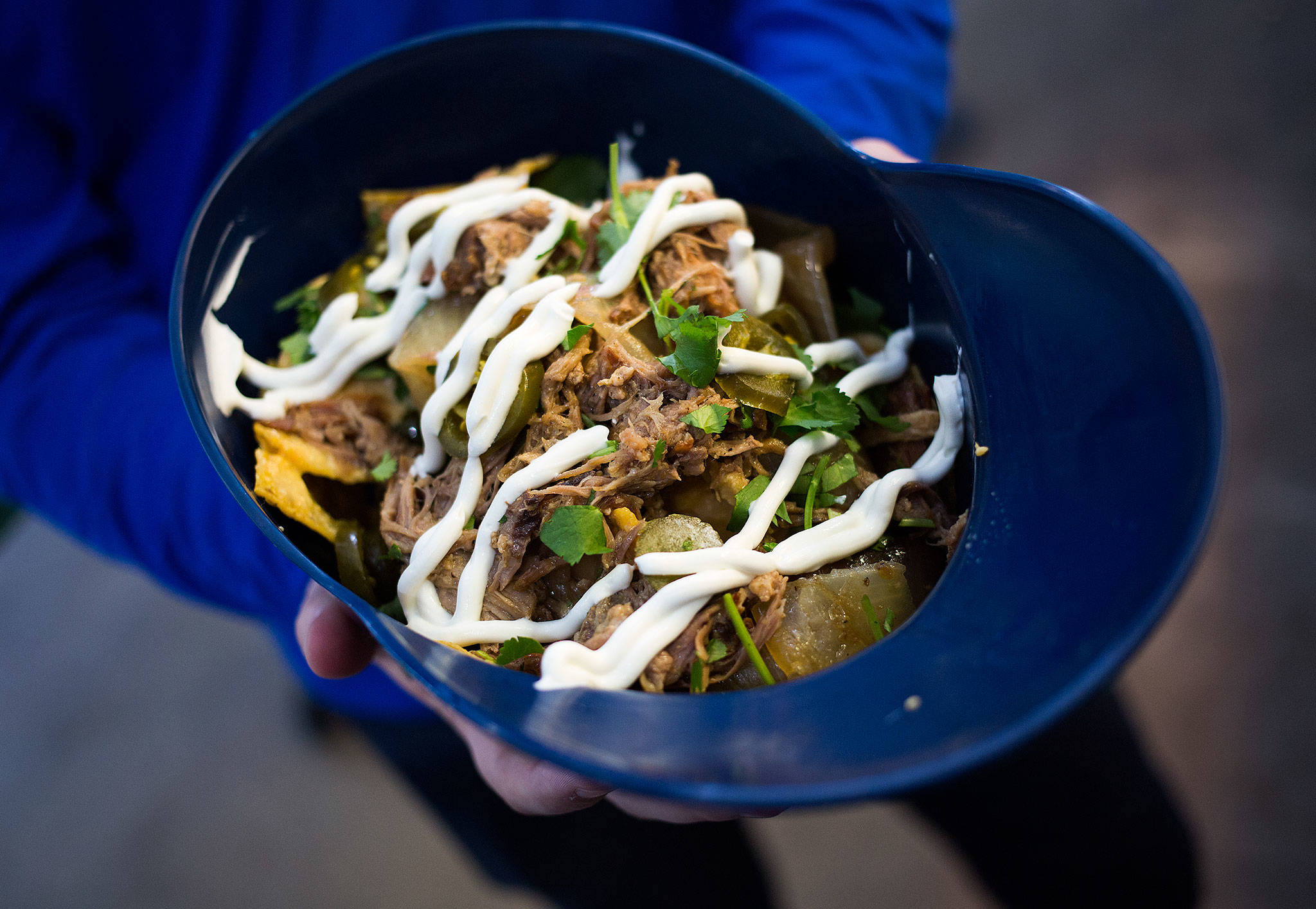 A family-size serving of Paseo’s Caribbean Nachos is served up in a Mariners helmet at T-Mobile Park. (Andy Bronson / The Herald)