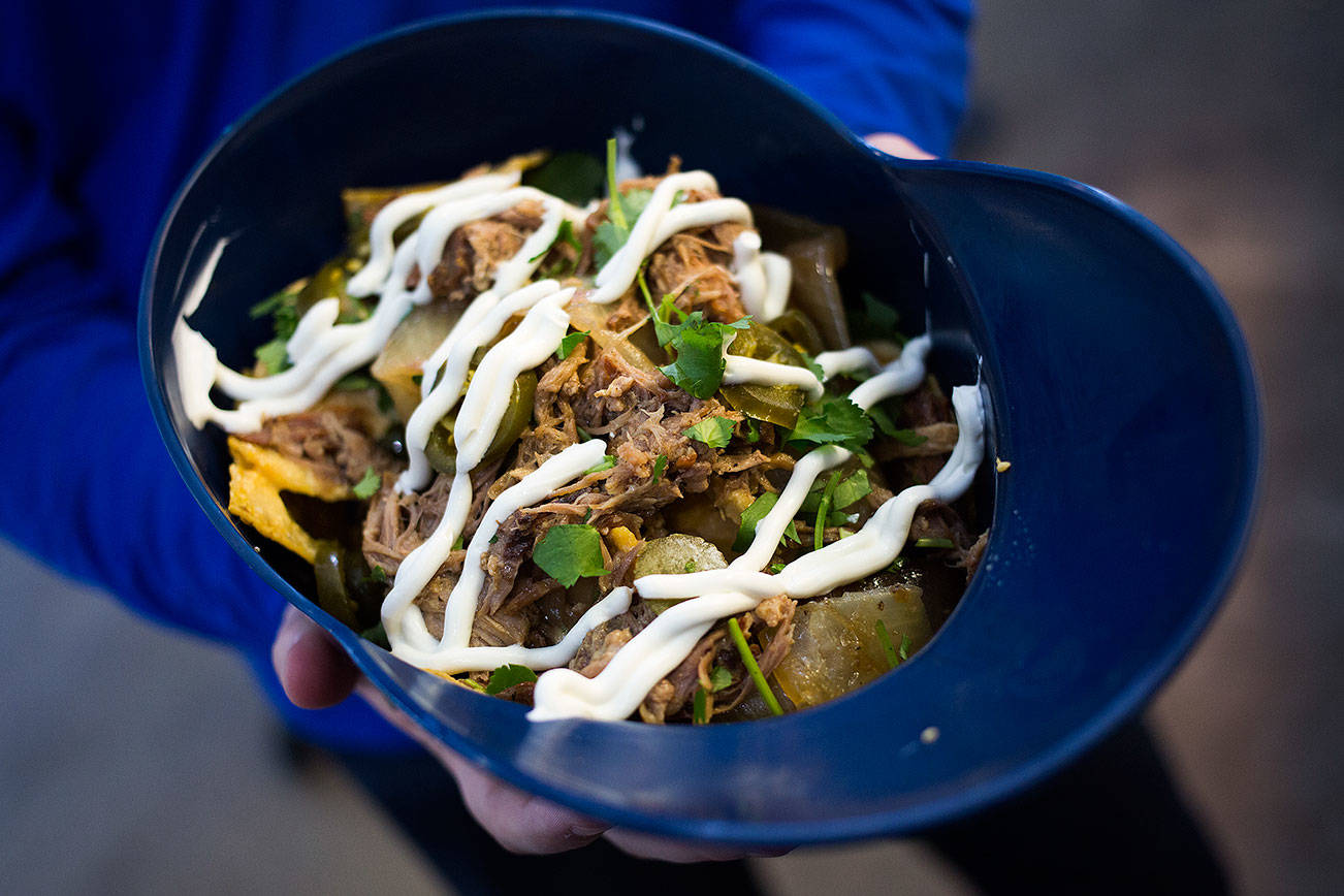 A family-sized Caribbean Nachos in a Mariners helmet from Paseo at T-Mobile Park on Thursday, March 28, 2019 in Seattle, Wash. (Andy Bronson / The Herald)