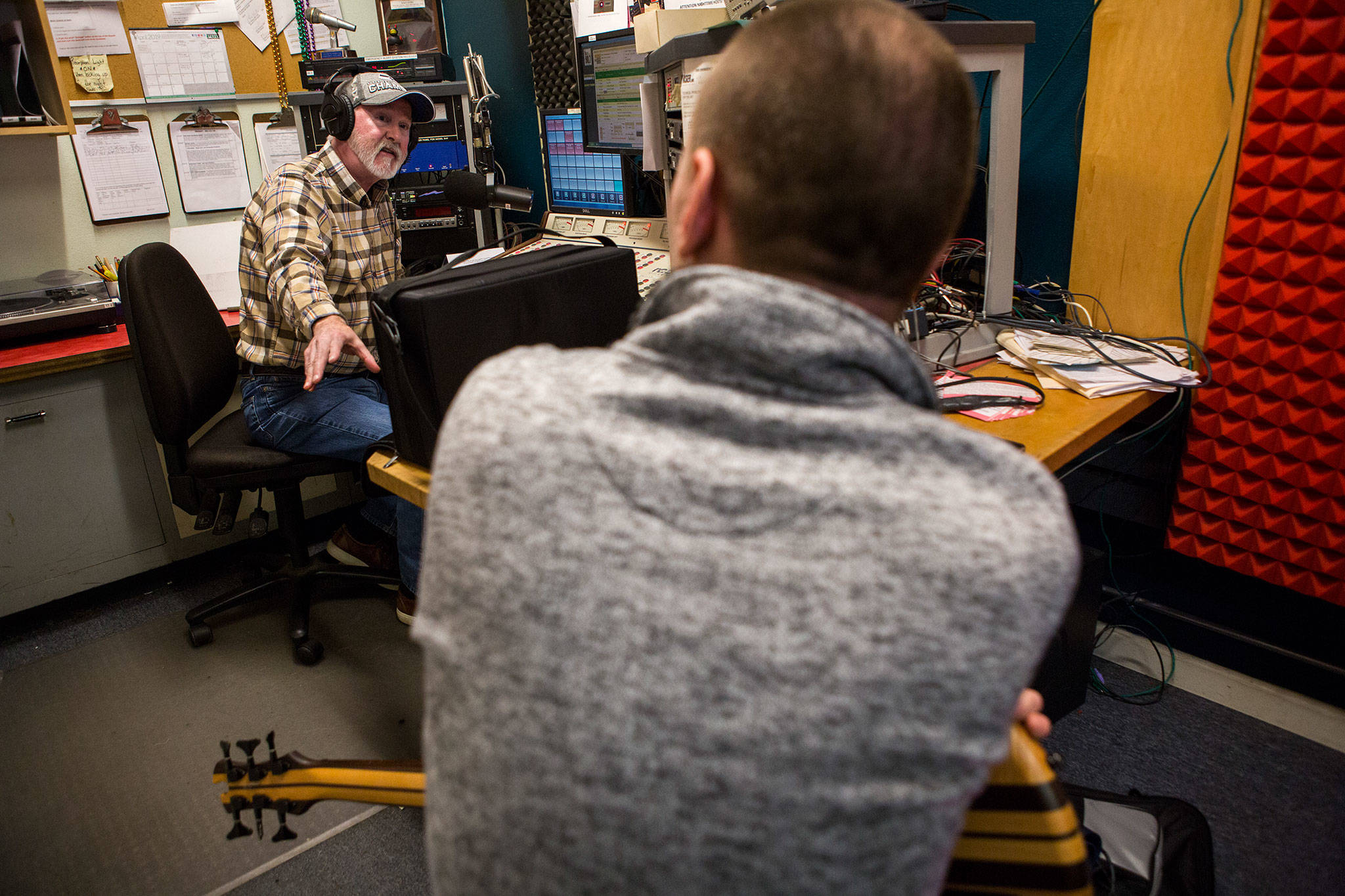 “Frettin’ Fingers” host Jim Hilmar talks with bass player Brendan Wires during his show at the KSER-FM studio. (Olivia Vanni / The Herald)