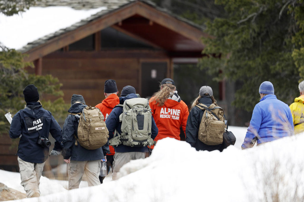 Investigators head into the forest along Mount Evans Road on Wednesday near Idaho Springs, Colorado, to search for a young Florida woman who authorities say was so “infatuated” with the Columbine school shooting they feared she was planning an attack in Colorado just days ahead of the 20th anniversary. (AP Photo/David Zalubowski)
