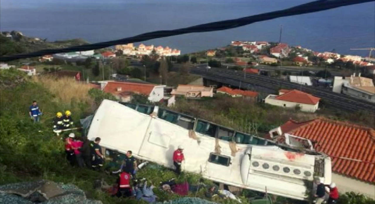 In this image from video, emergency services attend the scene after a tour bus crashed at Canico, on Portugal’s Madeira Island, on Wednesday . (TVI via AP)