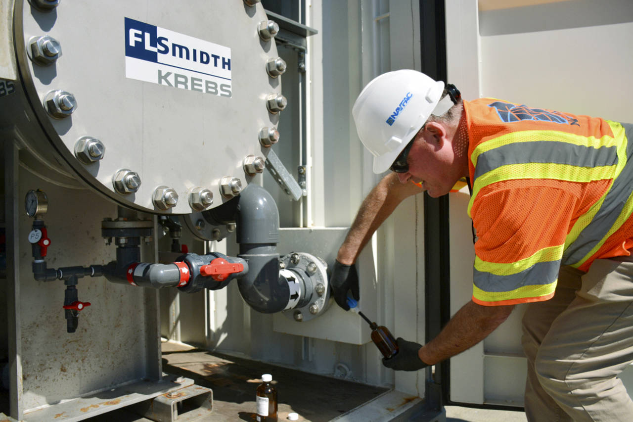 Naval Station Everett’s environmental protection specialist, David Warburton, checks water from the filter to make sure it meets permit requirements. (U.S. Navy)