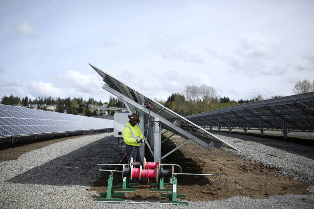 A&R Solar employee Diallo Josey puts the finishing touches on a row of solar panels Monday, April 15. (Julia-Grace Sanders/ The Herald)
