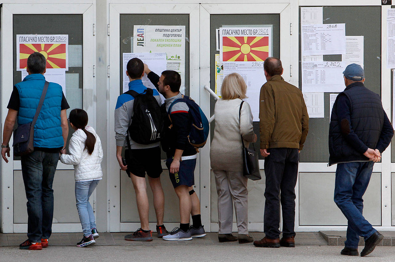 People check lists before voting in the presidential election Sunday outside a polling station in Skopje, North Macedonia. Polls were opened early Sunday in North Macedonia for presidential elections seen as key test of the government following deep polarization after the country changed its name to end a decades-old dispute with neighboring Greece over the use of the term “Macedonia”. (AP Photo/Boris Grdanoski)