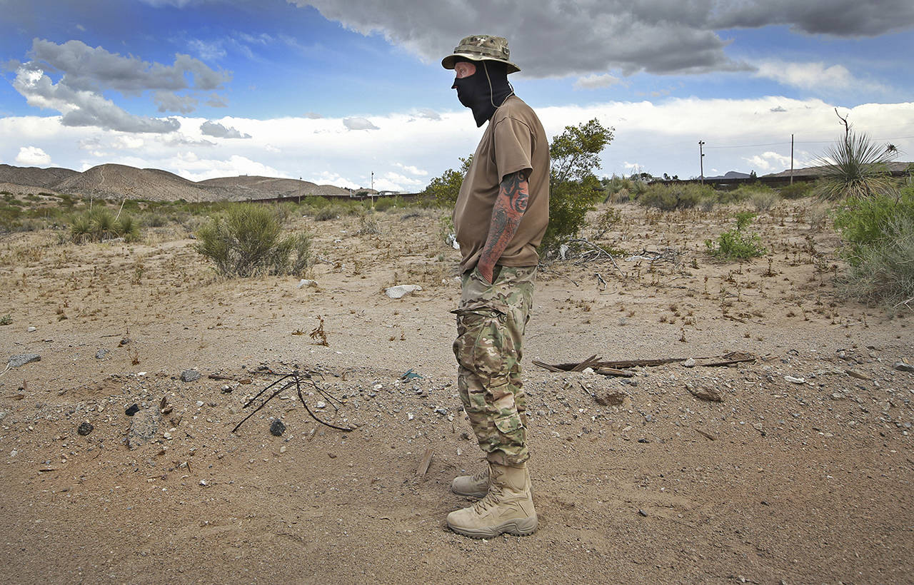Viper, a member of the United Constitutional Patriots, stands dejected after Union Pacific Police evicted the group from their camp in Anapra, New Mexico, on Tuesday. (Mark Lambie/The El Paso Times via AP)
