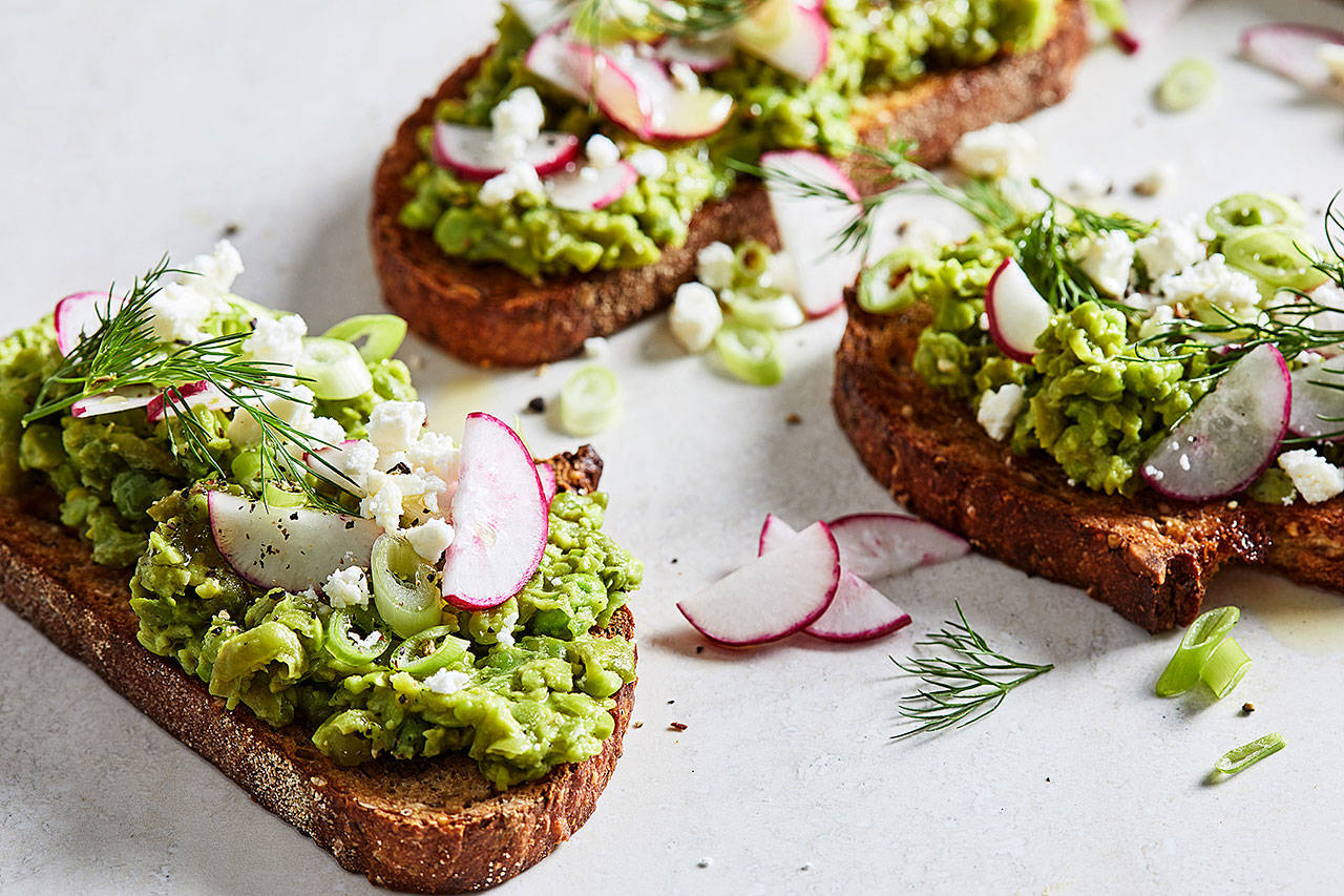 Top sweet pea toasts with sliced radishes and scallions, dill fronds and crumbled feta. (Photo by Stacy Zarin Goldberg for The Washington Post)