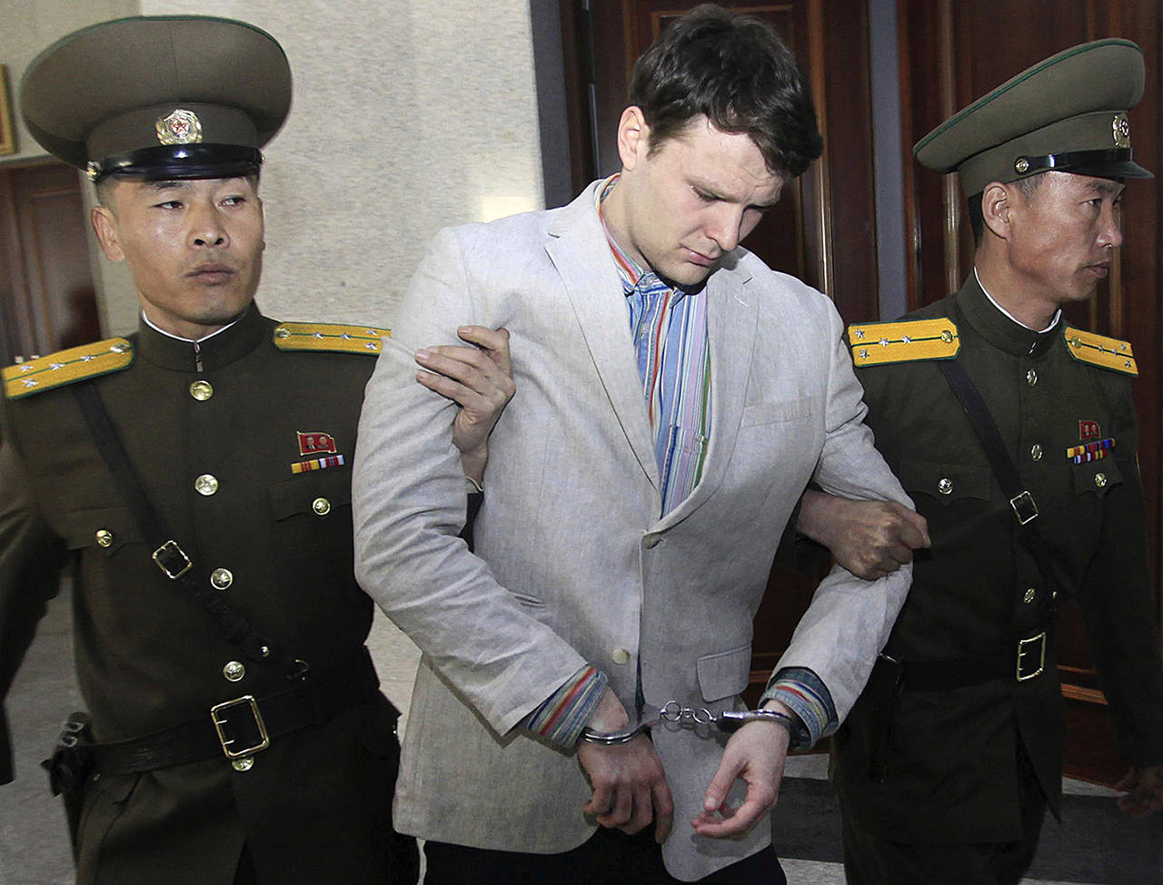 In this March 16, 2016, photo, American student Otto Warmbier (center) is escorted at the Supreme Court in Pyongyang, North Korea. North Korea reportedly insisted the U.S. pay $2 million in medical costs in 2017 before it released Warmbier while he was in a coma. (AP Photo/Jon Chol Jin, File)