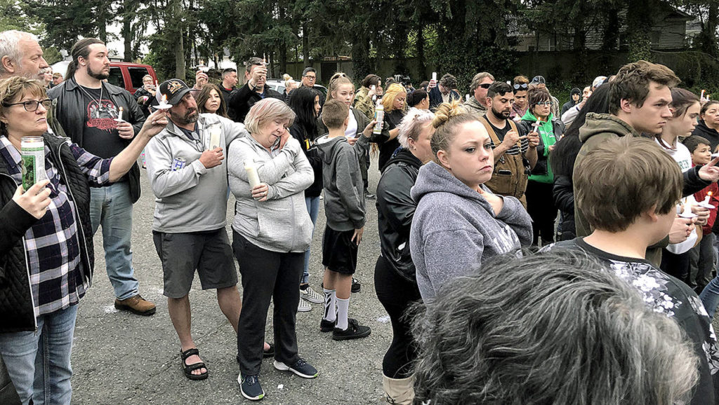 Dozens of people gathered Thursday night to remember Jae An, 58, a mini mark clerk killed in a robbery on Broadway in Everett. (Caleb Hutton / The Herald)

