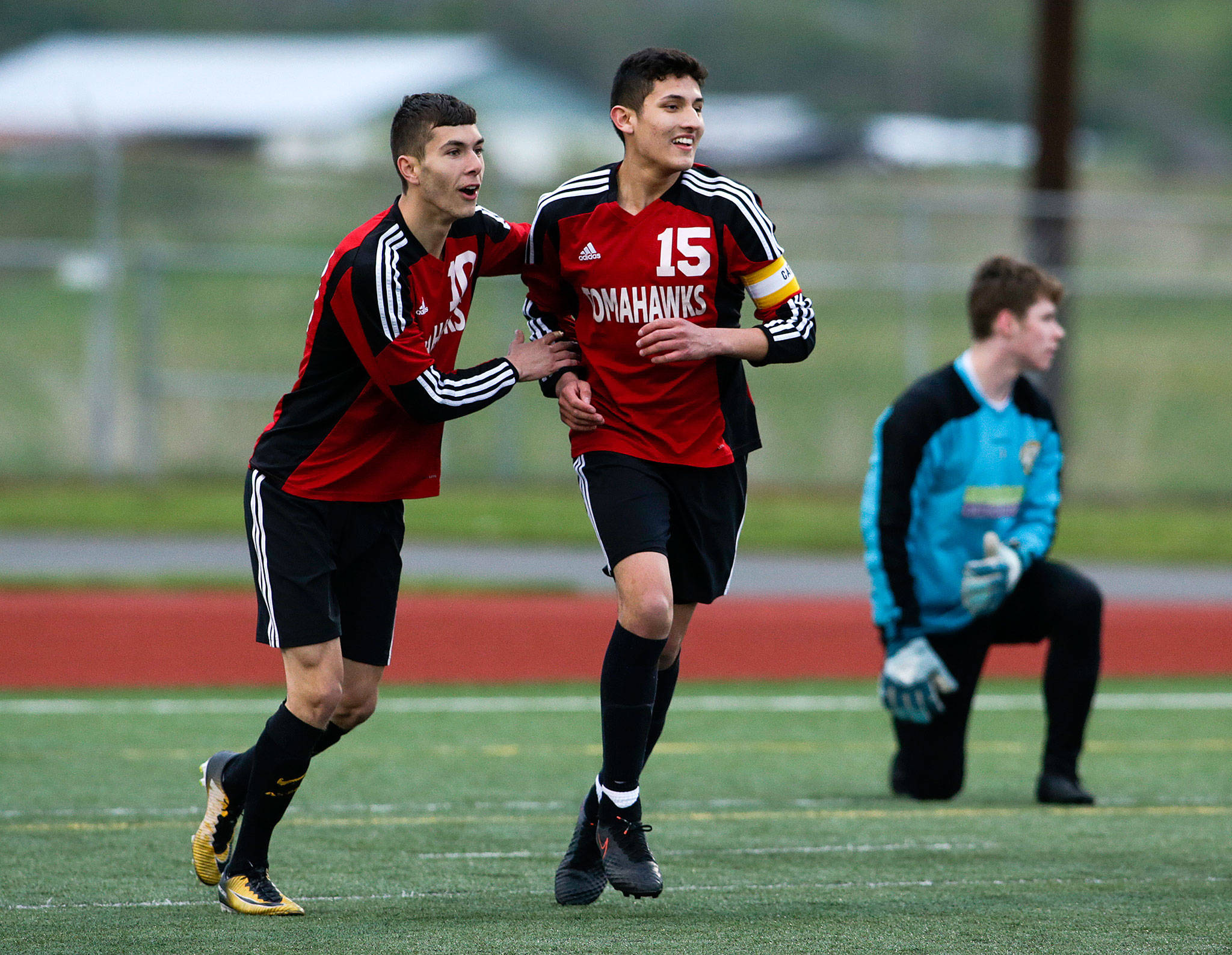 Marysville Pilchuck’s Leo Jaramillo (15) is congratulated by teammate Kyle Matson after scoring a sixth-minute goal in a 5-1 win over Everett on Friday night at Quil Ceda Stadium in Marysville. The victory clinched the second consecutive Wesco 3A/2A title for Jaramillo and the Tomahawks. (Andy Bronson / The Herald)