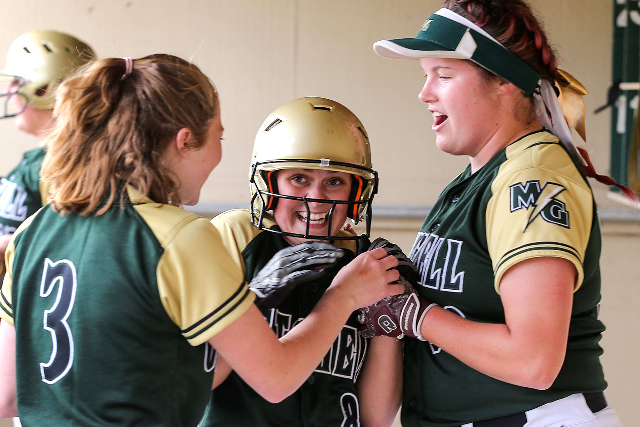 Marysville Getchell’s Skyleigh Morrison (center) is congratulated by teammates Erica Martin (left) and Brionna Palm after scoring a run against Marysville Pilchuck on April 26, 2019, at Marysville Getchell High School. (Kevin Clark / The Herald)