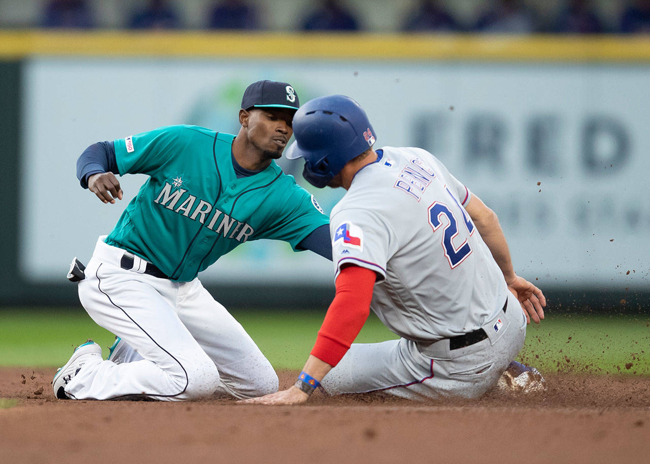 Mariners second baseman Dee Gordon (left) tags out the Rangers’ Hunter Pence who was trying to steal second base during the second inning of a game on April 26, 2019, in Seattle. (AP Photo/Stephen Brashear)