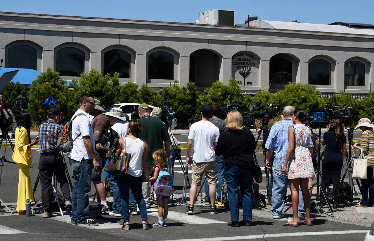 Neighbors and media members gather outside of the Chabad of Poway Synagogue on Saturday in Poway, California. (AP Photo/Denis Poroy)