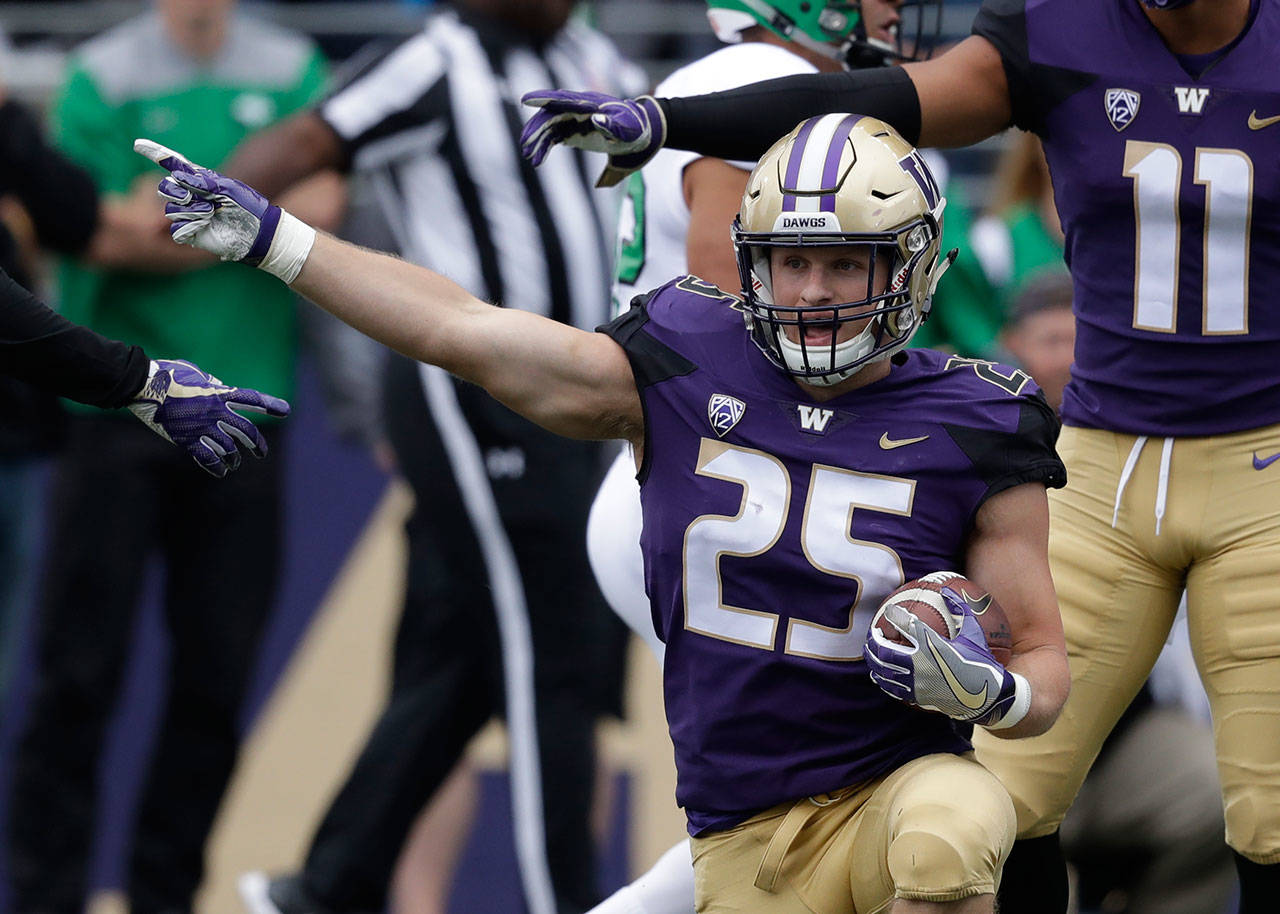 Washington’s Ben Burr-Kirven signals after recovering a fumble during a game against North Dakota on Sept. 8, 2018, in Seattle. (AP Photo/Elaine Thompson)