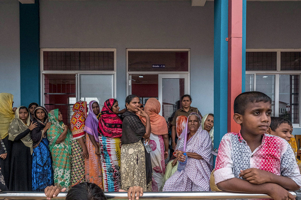 Residents from the area where a gunfight took place between authorities and suspected terrorists wait at a nearby school to go back to their houses in Sainthamaruthu. (Asanka Brendon Ratnayake for the Washington Post)