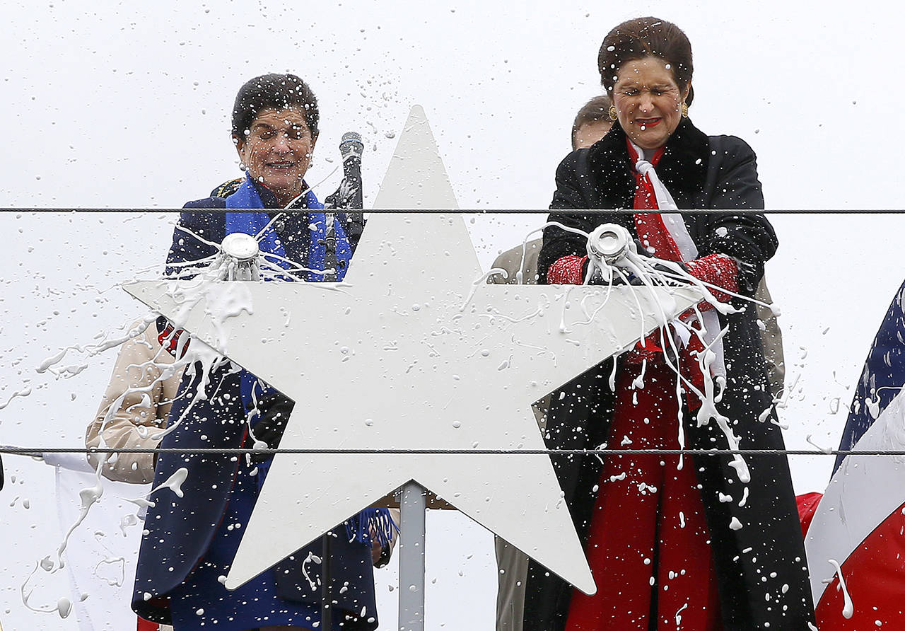 Luci Baines Johnson (left) and her sister, Lynda Johnson Robb, smash champagne bottles to christen the Lyndon B. Johnson, the third Zumwalt-class guided missile destroyer, built at Bath Iron Works, on Saturday in Bath, Maine. Johnson and Robb and the daughters of the former president. (AP Photo/Robert F. Bukaty)
