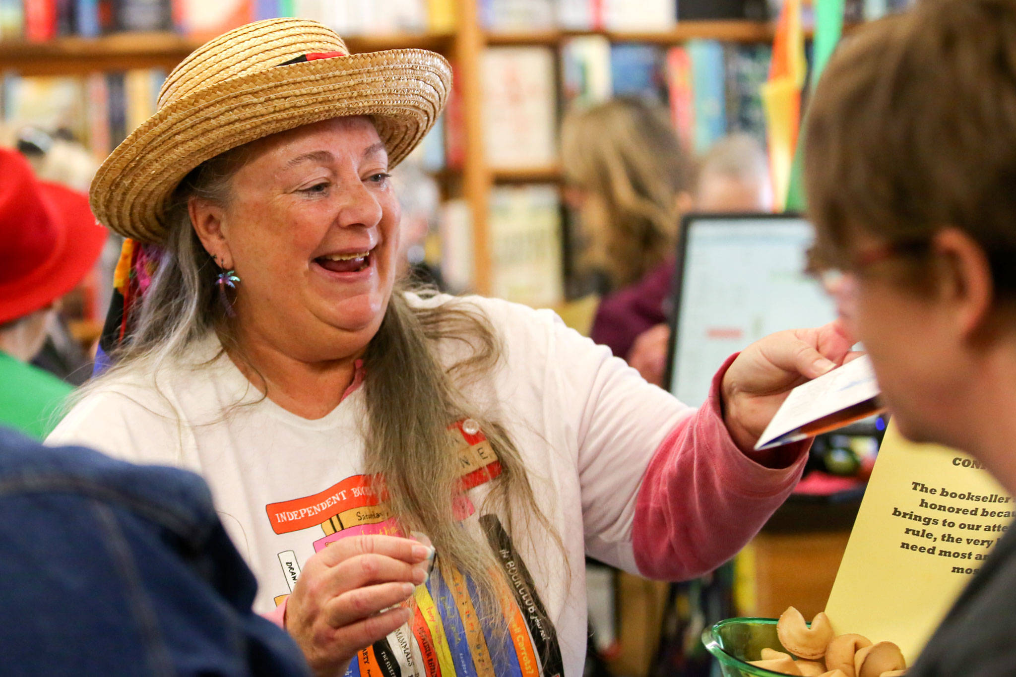Elaine Mattson reaches to stamp an Independent Bookstore Day Challenge passport at Edmonds Bookshop. (Kevin Clark / The Herald)
