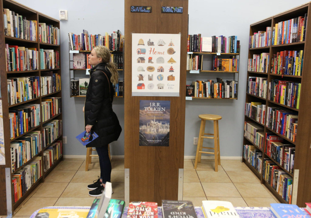 Lauren Hope browses the shelves of Neverending Bookstore in Edmonds. People who visited 21 stores earned a 25-percent discount for the entire year. (Kevin Clark / The Herald)
