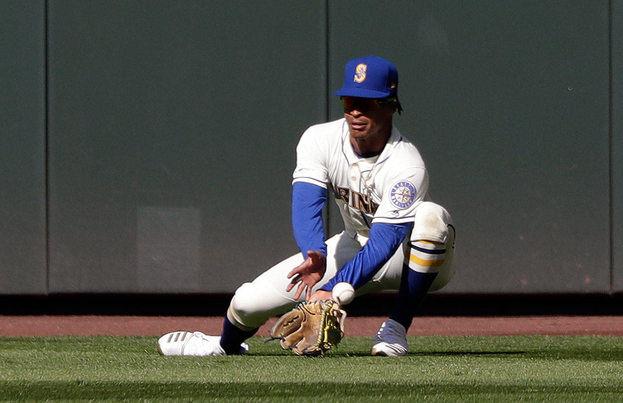 Seattle Mariners center fielder Mallex Smith misplays a fly ball from Texas Rangers’ Elvis Andrus for an error in the ninth inning of Sunday’s game in Seattle. (AP Photo/Elaine Thompson)