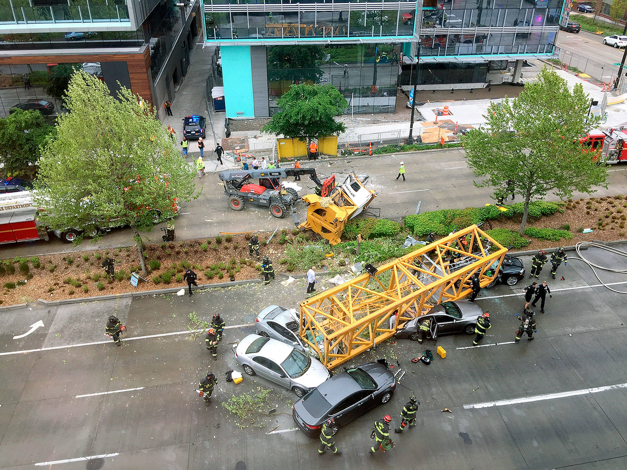 Firefighters and police work to clear the scene where a construction crane fell from a building on Google’s new Seattle campus on Saturday. (AP Photo/Frank Kuin)