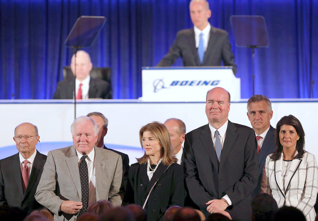Boeing Co. Chairman and Chief Executive Officer Dennis Muilenburg (top) introduces the board of directors — including Nikki Haley (right) and Caroline Kennedy (center) — at the company’s annual general meeting in Chicago on Monday. (John Gress/Pool Photo via AP) 
