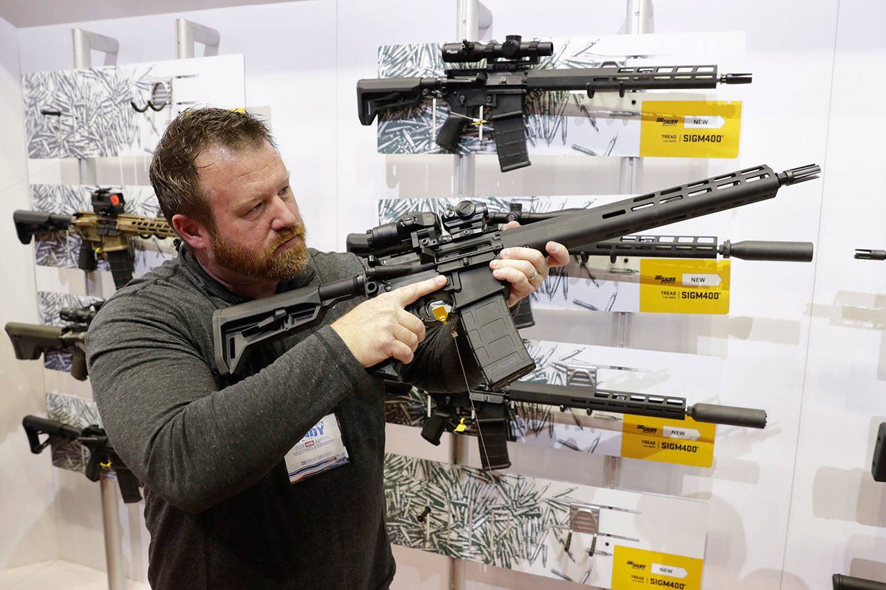 Bryan Oberc, of Munster, Indiana, tries out an AR-15 from Sig Sauer in the exhibition hall Saturday at the National Rifle Association Annual Meeting in Indianapolis. (AP Photo/Michael Conroy)