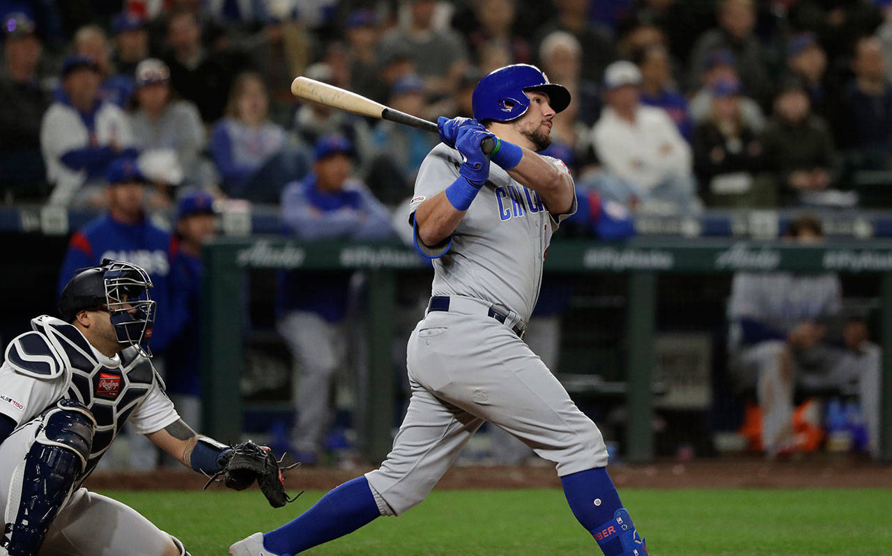 The Cubs’ Kyle Schwarber (right) hits a two-run home run in the eighth inning as Mariners catcher Omar Narvaez looks on during a game on April 30, 2019, in Seattle. (AP Photo/Elaine Thompson)
