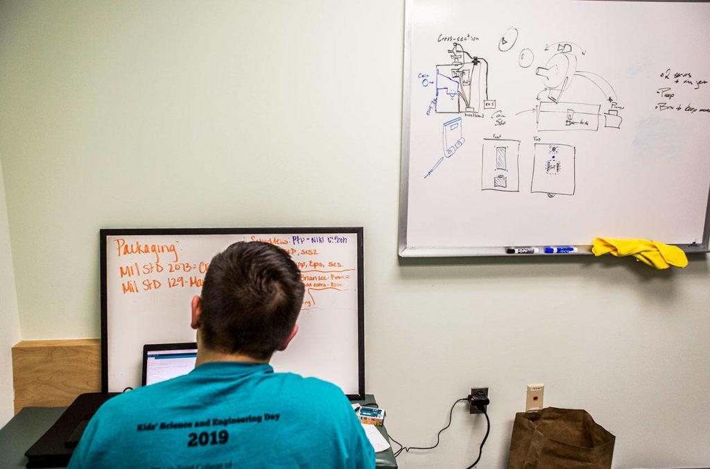 Daniel Aucoin works on software code for his groups “sh*tty robot” at TheLab@everett. (Olivia Vanni / The Herald) 
