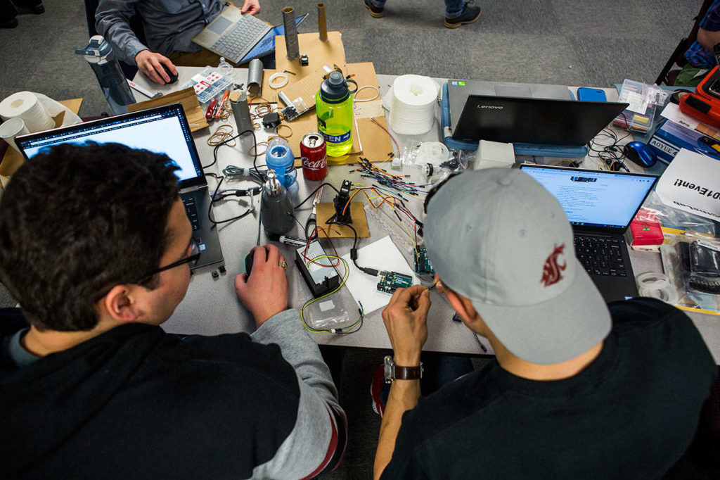 Team members discuss plans for their “sh*tty robot” at TheLab@everett. (Olivia Vanni / The Herald)
