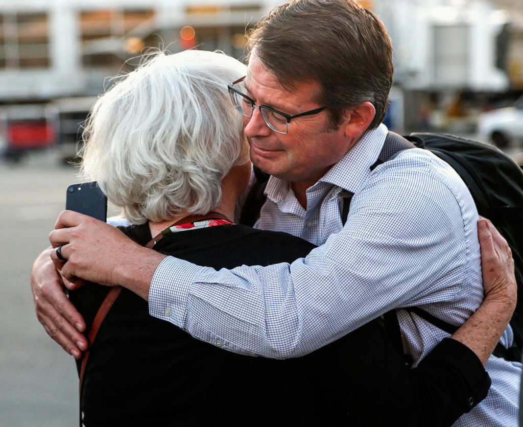 During the plane-side ceremony at Sea-Tac, John Price gets a hug from his mother, Judy Price, 74. Judy’s mother was the sister of Daniel Guisinger, an Everett sailor killed at Pearl Harbor. (Dan Bates / The Herald)
