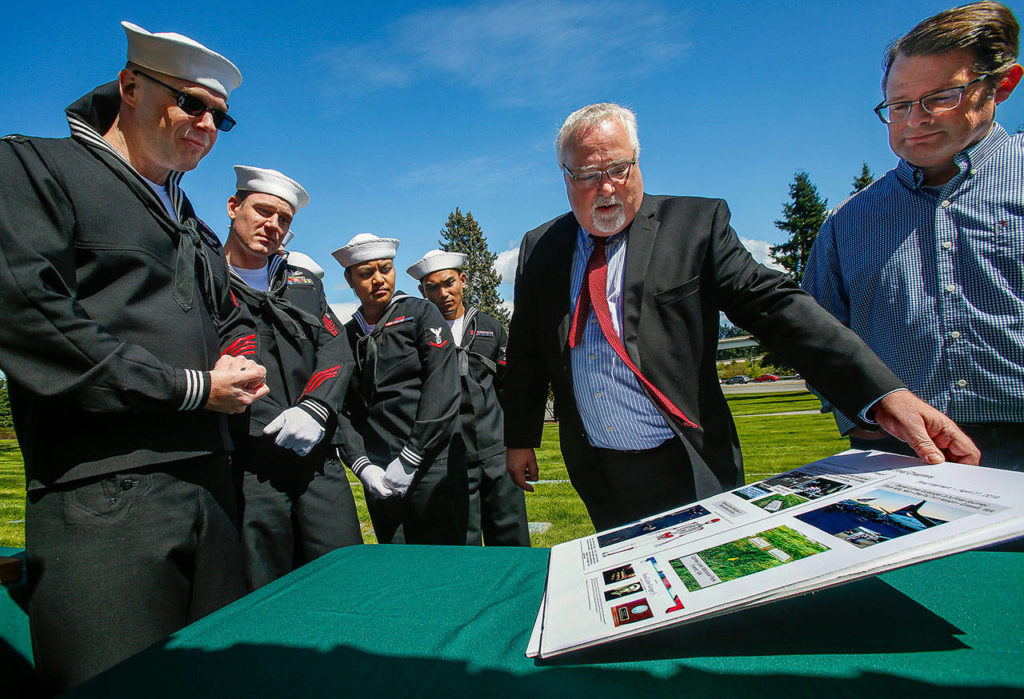 At Cypress Lawn Memorial Park, Dan Hoeglund, of Lake Stevens, shows a display that tells the story of his great uncle, Daniel Guisinger Jr. (Dan Bates / The Herald)
