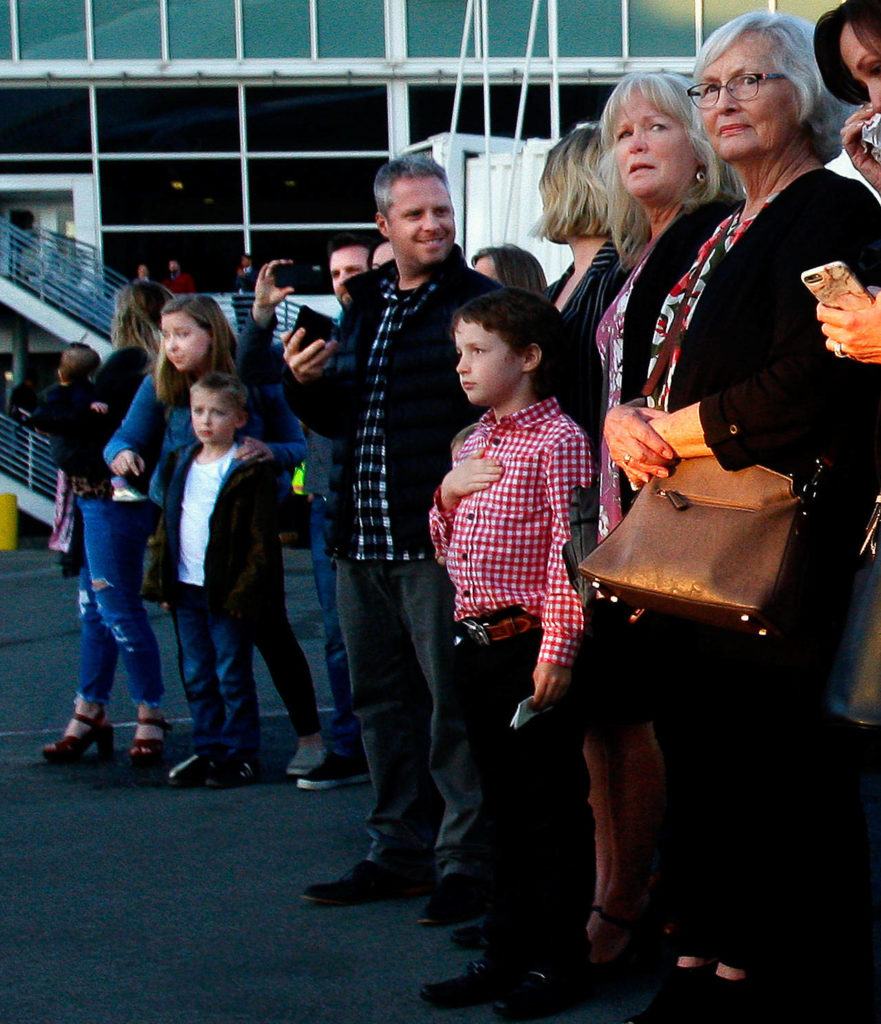 Riot Cook, 8, holds his hand over his heart during the plane-side ceremony at Sea-Tac Airport on April 24. He is among a large family there to honor Daniel Guisinger Jr., whose remains were recently identified. The Everett sailor died at Pearl Harbor. (Dan Bates / The Herald)
