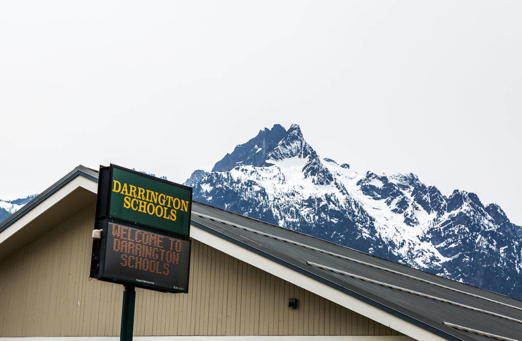 Whitehorse Mountain peeks over a Darrington schools sign, marking the campus that includes Darrington High School and Darrington Elementary School. (Olivia Vanni / The Herald)
