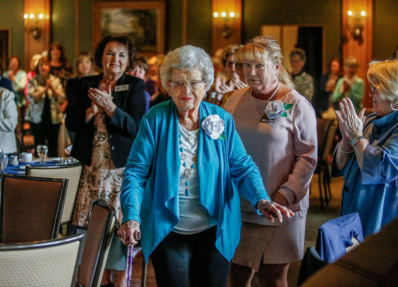 As Mary Elaine Burgess, an Assistance League volunteer for 50 years, walks to receive the group’s Circle of Honor Award, Thursday, everyone in the Everett Golf and Country Club stands and applauds. (Dan Bates / The Herald)