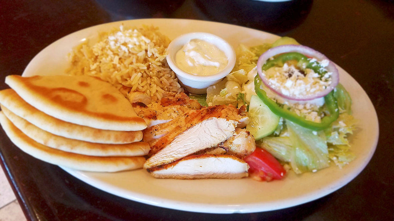 A plate of broiled marinated chicken, rice and pasta pilaf, Greek salad, tzatziki and pita at Kafe Neo. (Sharon Salyer / The Herald)