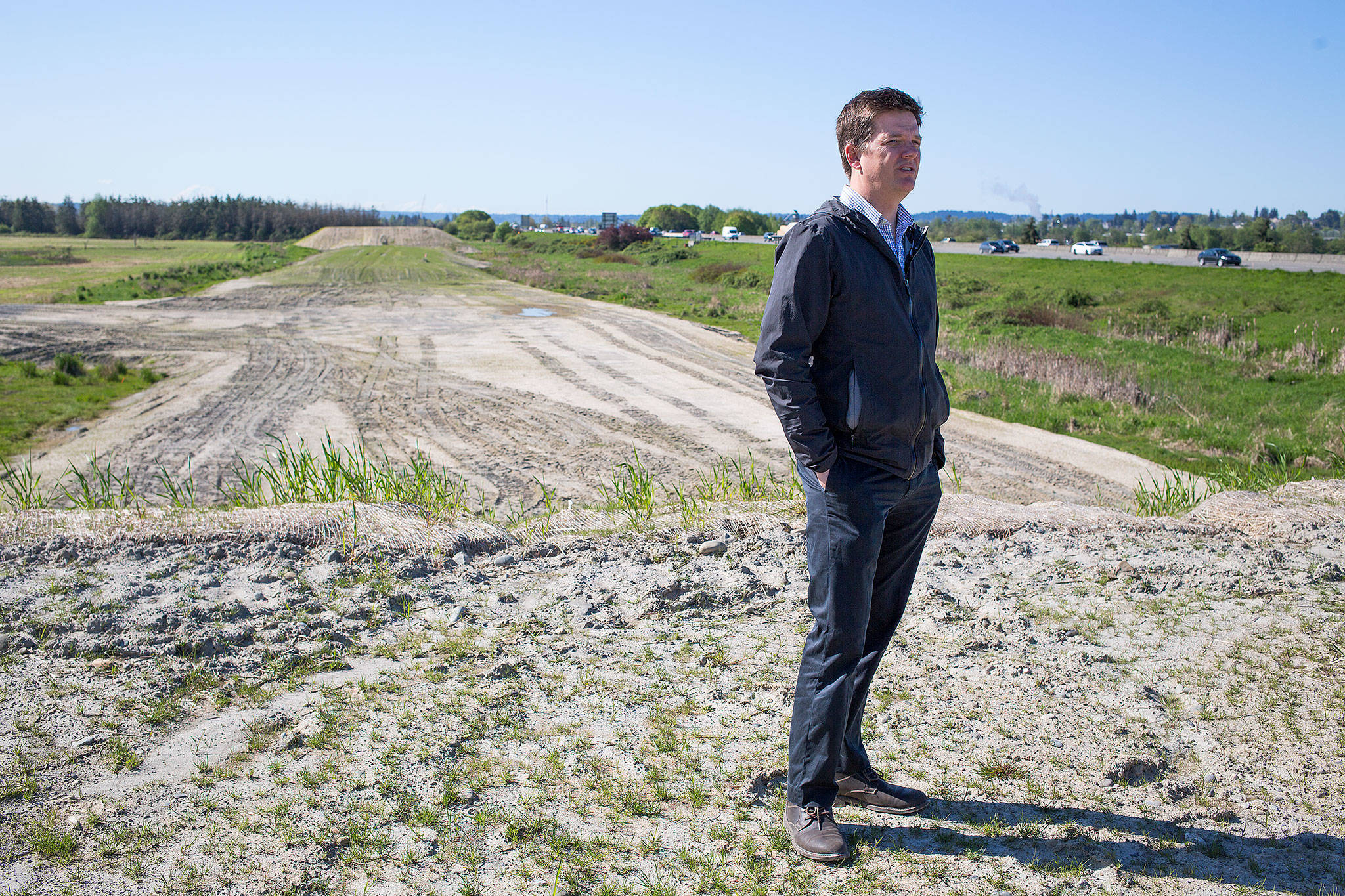 Erik Gerking, the Port of Everett’s director of environmental programs, walks along the separation dike on the east side of I-5 on Monday. The port, working with a private company, has been stockpiling clean fill dirt for an upcoming habitat project in the Snohomish River estuary. (Andy Bronson / The Herald)