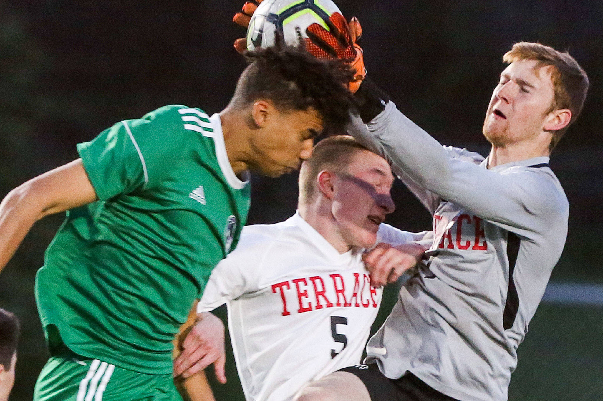 Mountlake Terrace senior Ben Leonard (right) defends a header attempt during Tuesday night’s match against Edmonds-Woodway. Leonard is not only a talented goalkeeper, but also a skilled saxophonist who’s headed to DePaul University in Chicago with a music scholarship. (Kevin Clark / The Herald)