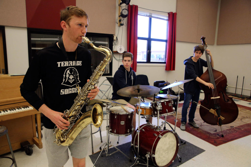 Ben Leonard (left-right) practices the saxophone alongside drummer Josh Setala and bassist Andrew Vinther on Tuesday afternoon at Mountlake Terrace High School. The three friends and classmates formed a jazz band called Blue North Trio that plays various gigs around the area. (Kevin Clark / The Herald)
