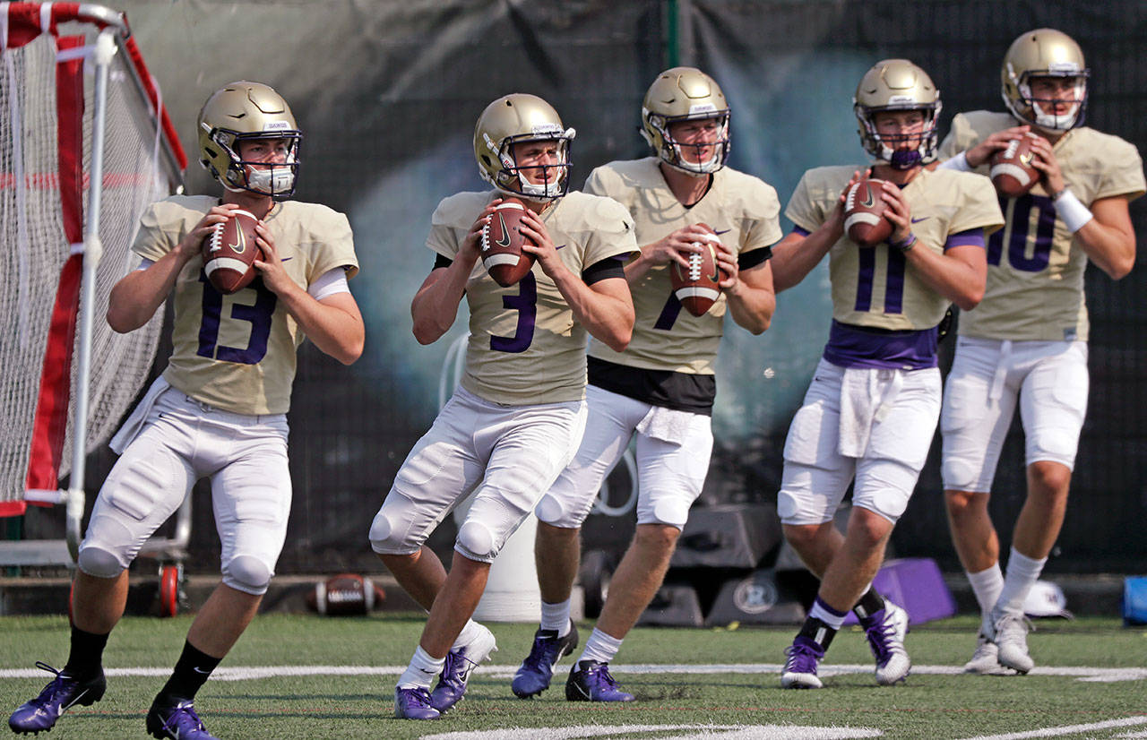 Washington quarterbacks Jake Haener (13), Jake Browning (3), Colson Yankoff (7), Jacob Sirmon (11) and Jacob Eason (10) throw during drills at a practice on Aug. 10, 2018, in Seattle. (AP Photo/Elaine Thompson)