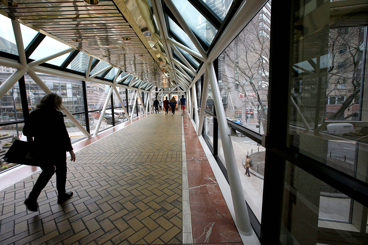 Steven Senne / Associated Press file                                Passers-by walk on a bridge between shopping centers, in Boston, in March. Marie