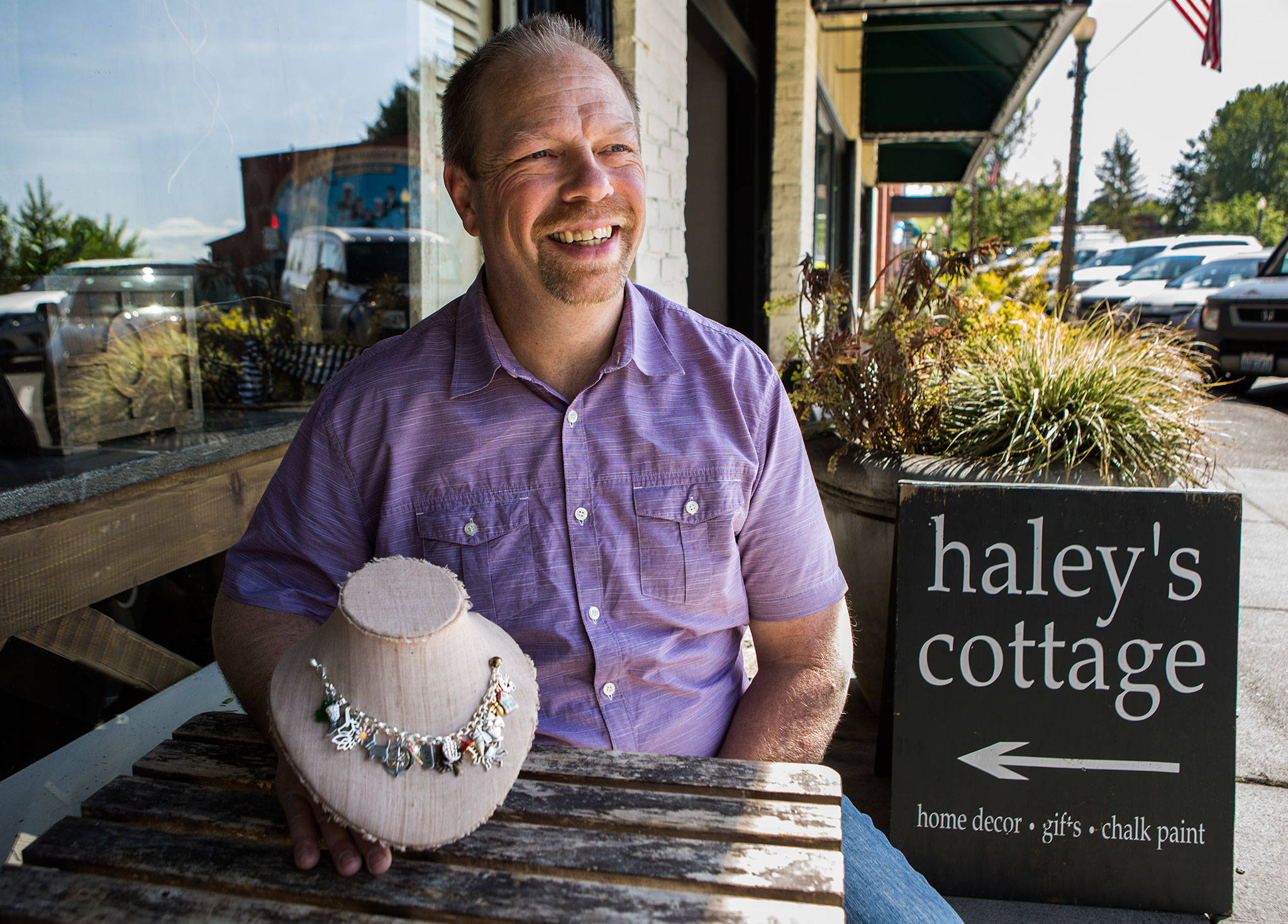 Rick Alles, president of the Historic Downtown Snohomish Association, with the charms being offered by different downtown businesses during the Charm Walk on Saturday in Snohomish. (Olivia Vanni / The Herald)