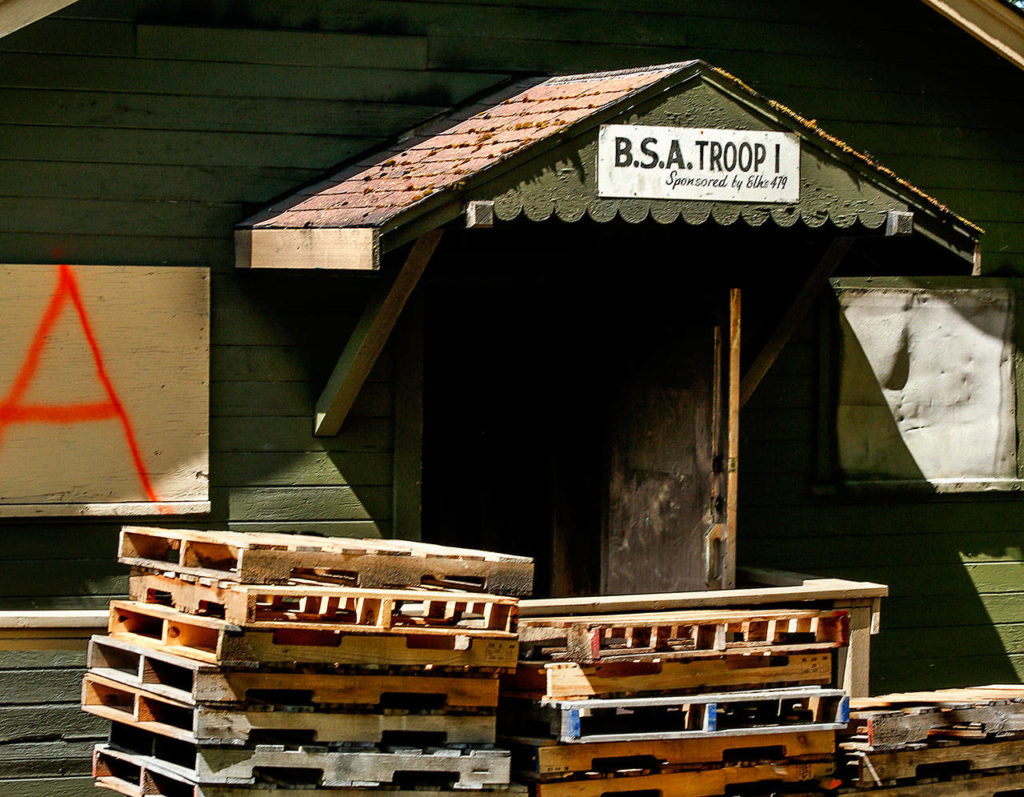 The former home of Everett’s Troop 1 is marked by a sign at the rear entrance of what was known as the Scout Shack. Wooden pallets await use during firefighter training at the building Tuesday. (Dan Bates / The Herald)
