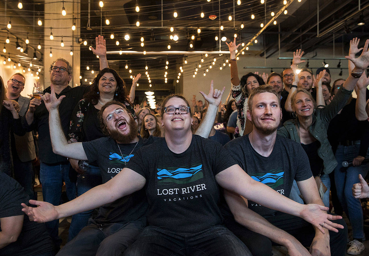 Deaf entrepreneurs Andrew St. Cyr, Jane Jonas, and Shawn Harrington co-owners of Lost River Vacations, participate in a group photo during a fundraiser at Red Bear Brewing Company in Washington, D.C., last month. (Photo for The Washington Post by Evelyn Hockstein)